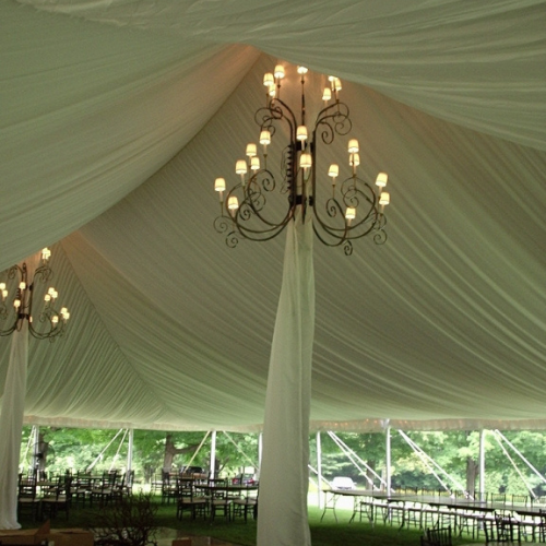 Lights set up underneath a white tent set up outdoors