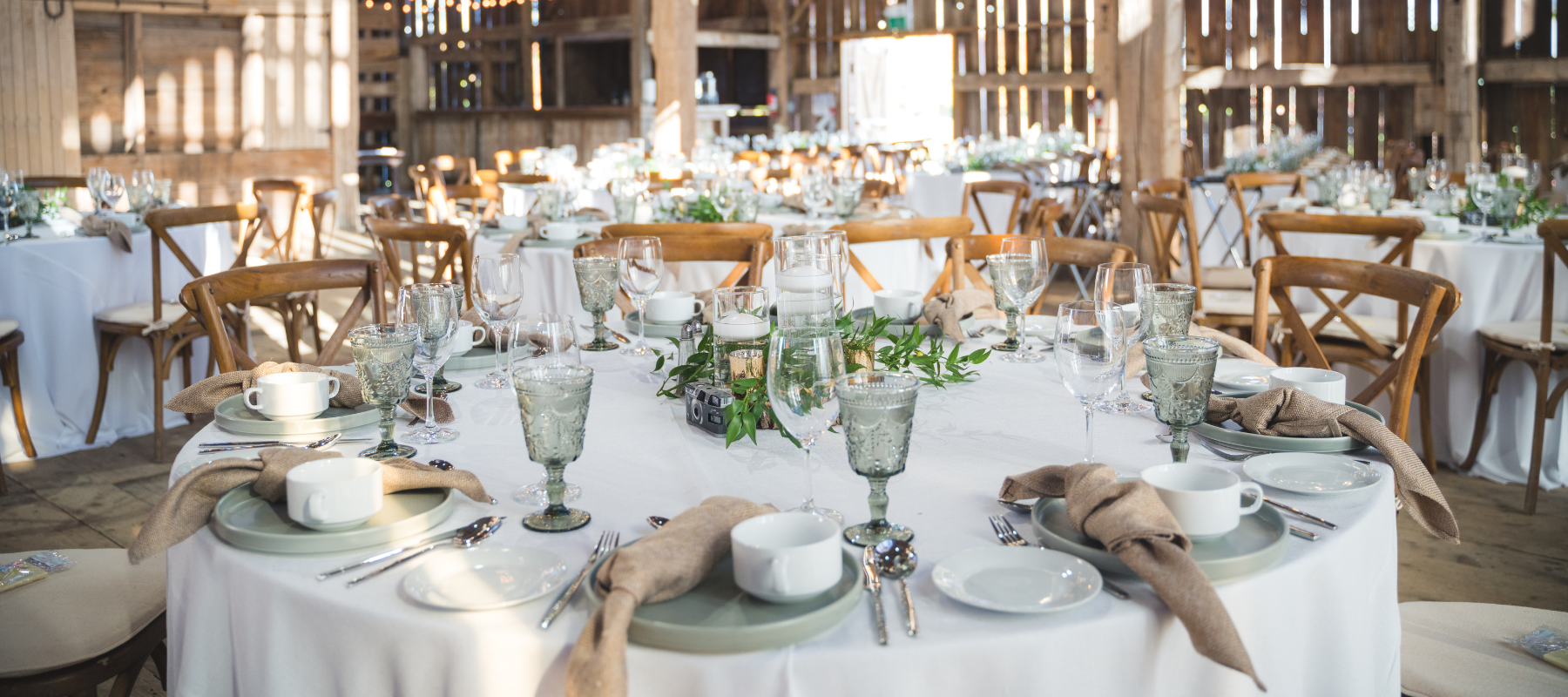 Wedding tables set up inside of a barn